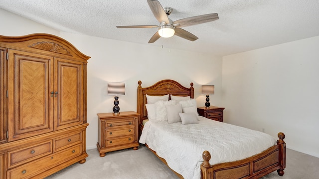 bedroom featuring ceiling fan, light colored carpet, and a textured ceiling