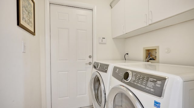 washroom featuring washer and clothes dryer and cabinets