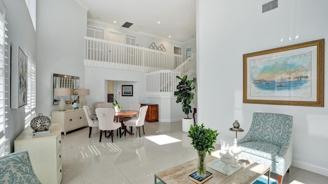 living room with light tile patterned floors, a high ceiling, and ornamental molding