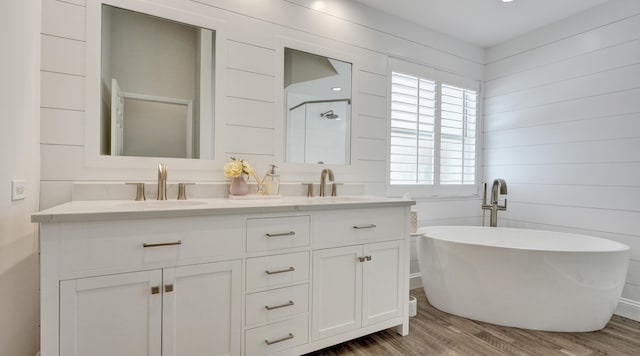 bathroom with wood walls, hardwood / wood-style floors, vanity, and independent shower and bath