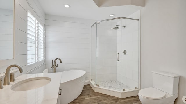 full bathroom with plenty of natural light, wood-type flooring, shower with separate bathtub, and toilet