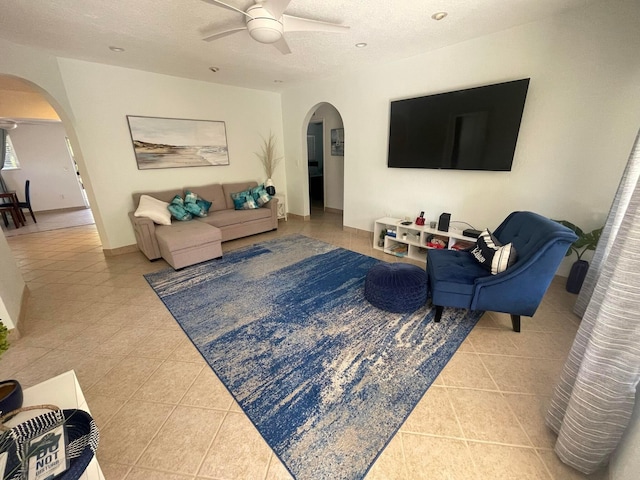 living room featuring light tile patterned flooring, a textured ceiling, and ceiling fan