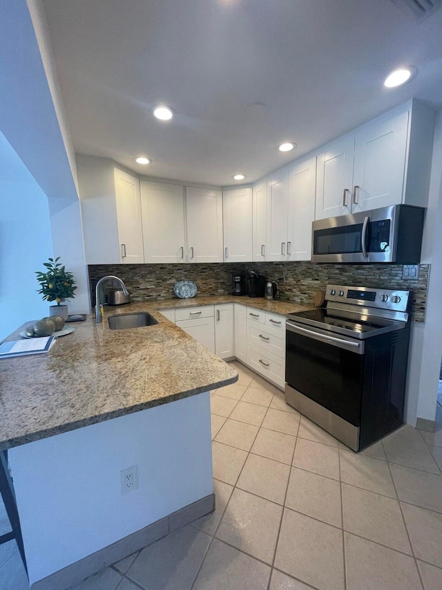 kitchen with white cabinets, kitchen peninsula, and stainless steel appliances