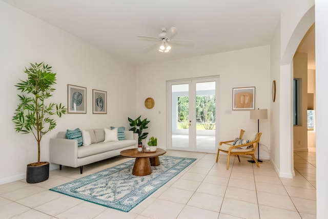 tiled living room featuring ceiling fan and french doors