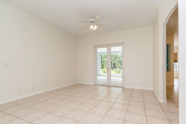 tiled empty room with ceiling fan and french doors