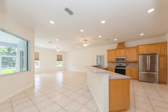 kitchen with stainless steel appliances, sink, kitchen peninsula, light tile patterned flooring, and ceiling fan