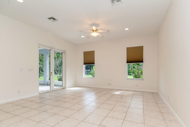 tiled spare room featuring ceiling fan and plenty of natural light