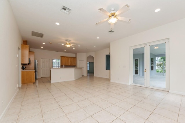 unfurnished living room featuring ceiling fan and light tile patterned floors