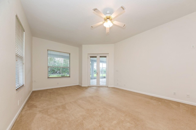 spare room featuring ceiling fan and light colored carpet