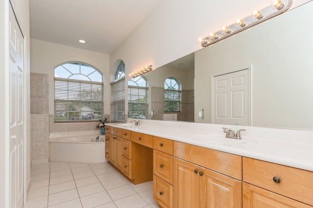 bathroom featuring tile patterned floors, a washtub, and vanity