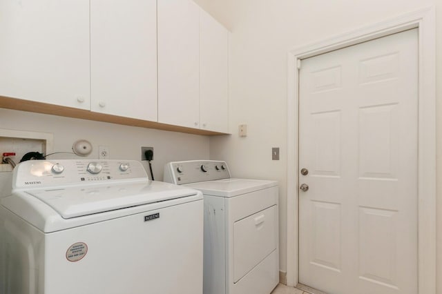 laundry area featuring washer and clothes dryer and cabinets