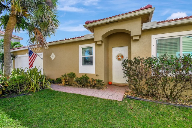 property entrance with a garage and a lawn