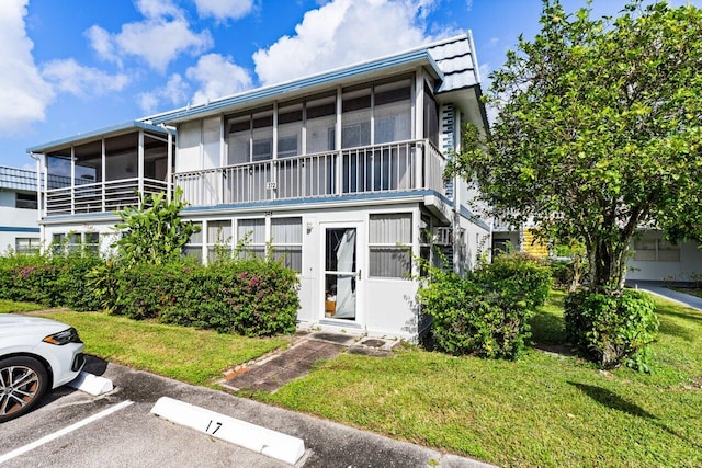 view of front of home with a sunroom and a front yard