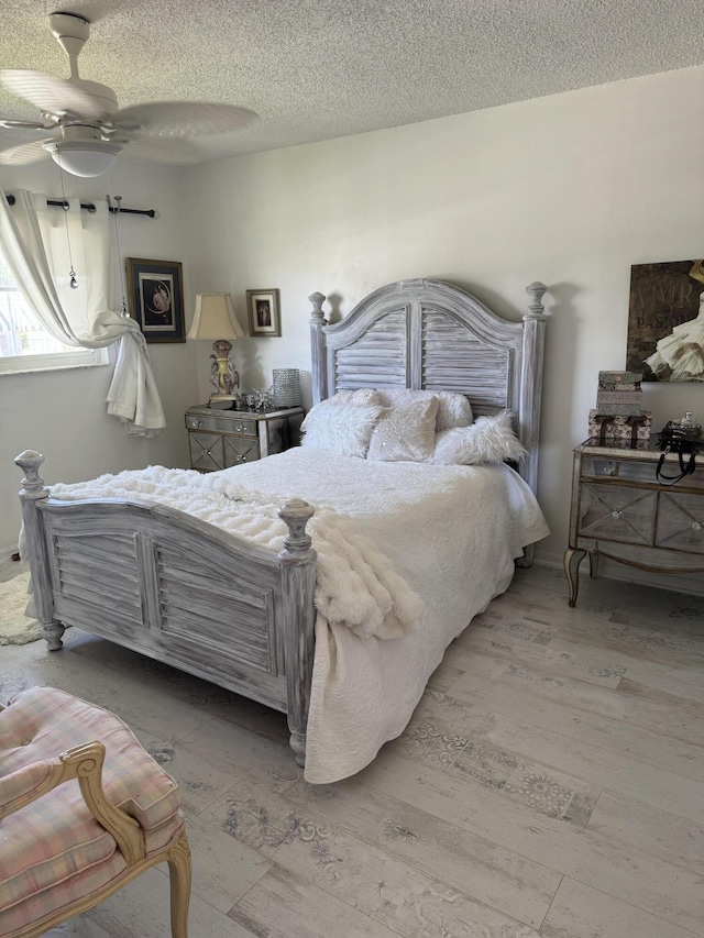 bedroom featuring a ceiling fan, a textured ceiling, and wood finished floors