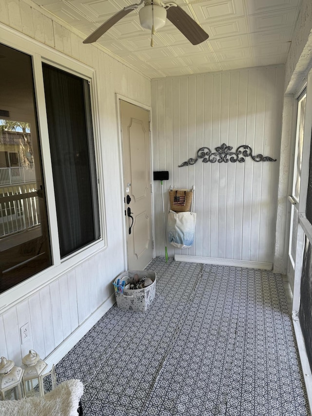 unfurnished sunroom with ceiling fan and an ornate ceiling