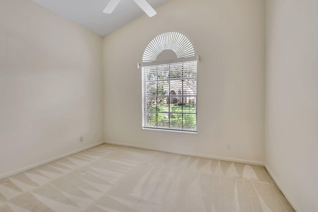 spare room with light carpet, vaulted ceiling, and ceiling fan