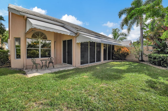 back of property with a yard and a patio area