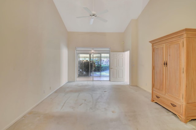 carpeted spare room with ceiling fan and high vaulted ceiling