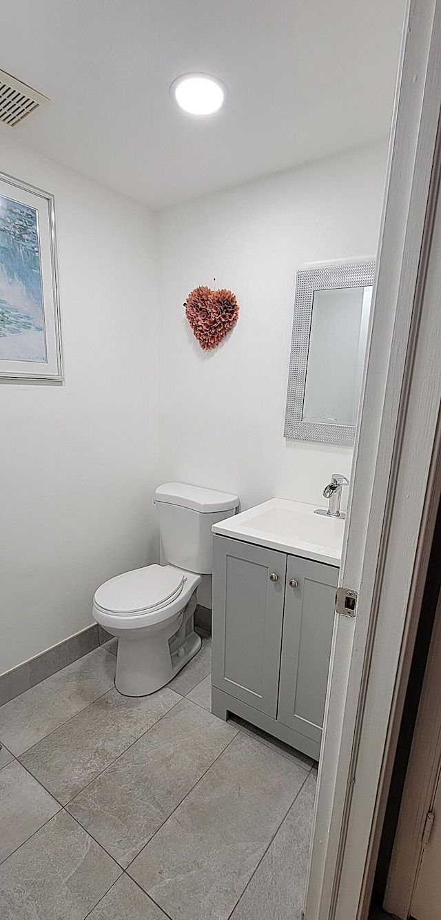 bathroom with tile patterned flooring, vanity, and toilet