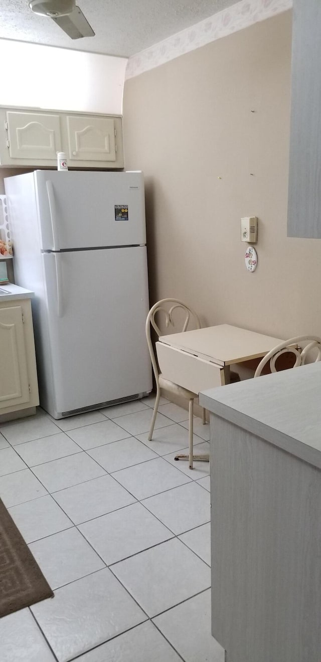 kitchen with light tile patterned floors and white refrigerator