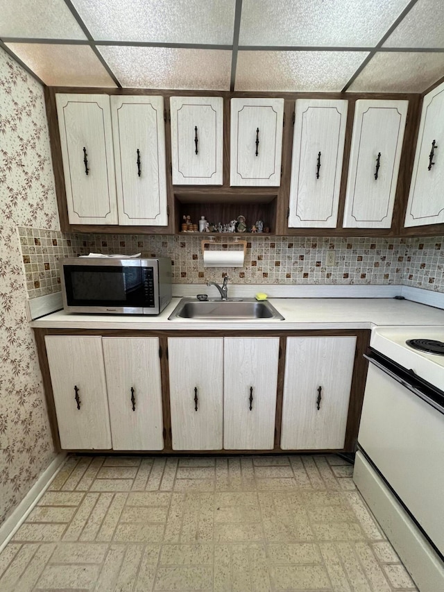 289 Piedmont G 289, Delray Beach, FL 33484 - kitchen with white electric range, sink, a drop ceiling, and decorative backsplash
