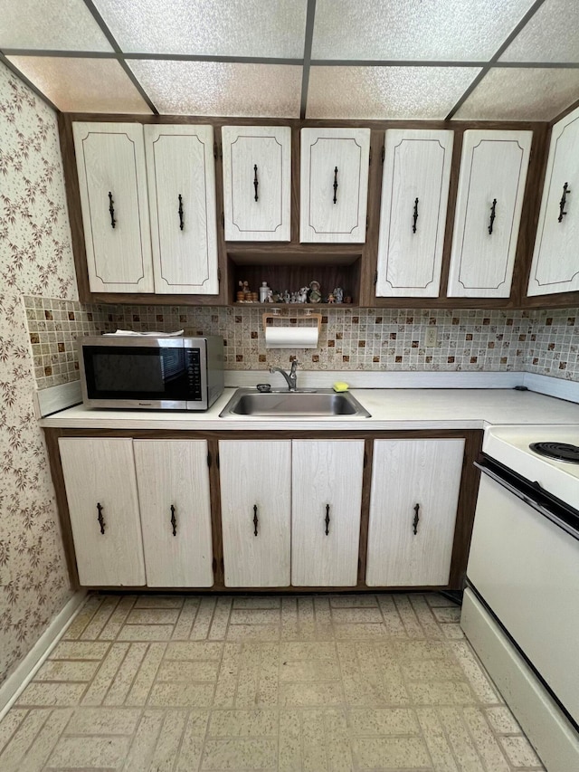 kitchen with white electric range, sink, a drop ceiling, and decorative backsplash