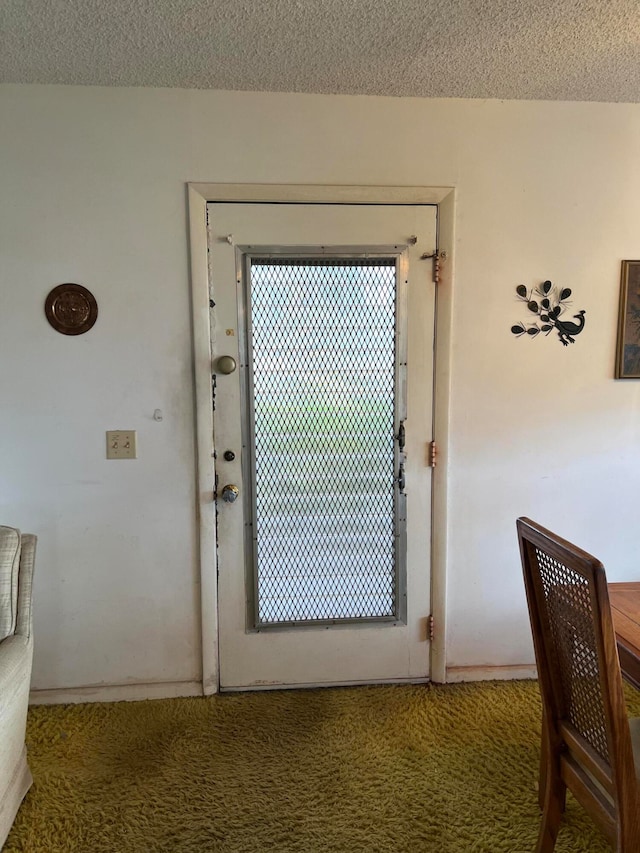 entryway featuring carpet flooring and a textured ceiling