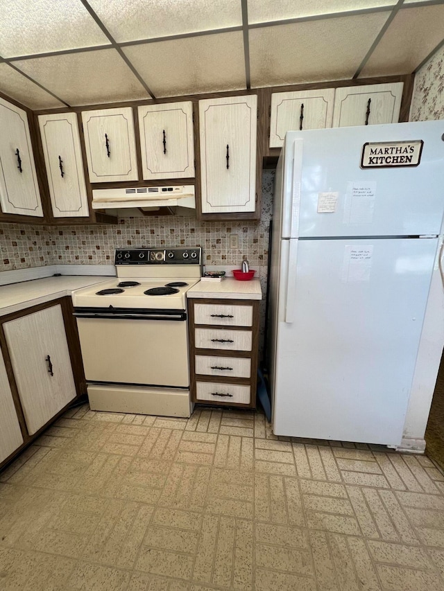 kitchen featuring decorative backsplash, a paneled ceiling, and white appliances