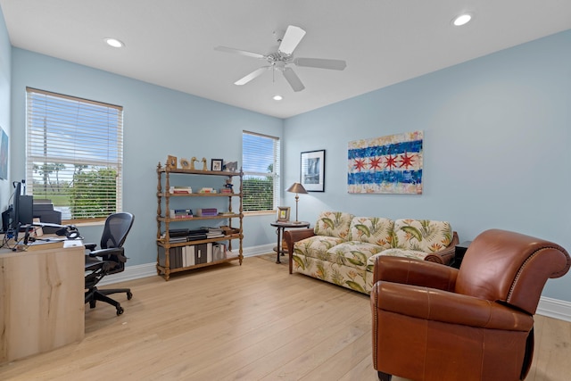 home office with ceiling fan, a wealth of natural light, and light hardwood / wood-style flooring