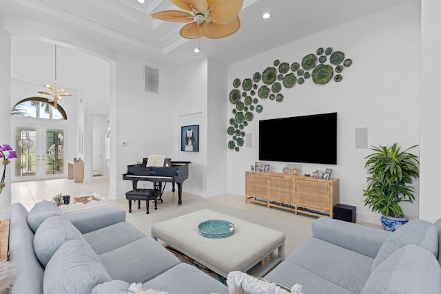 living room featuring ceiling fan with notable chandelier, a towering ceiling, tile patterned floors, french doors, and ornamental molding