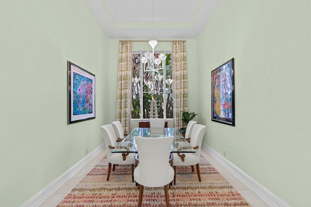 dining space featuring ornamental molding, a raised ceiling, an inviting chandelier, and tile patterned flooring