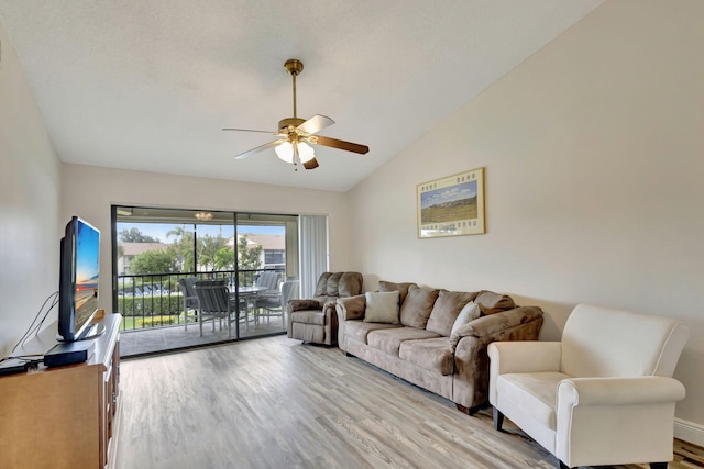 living room with light hardwood / wood-style floors, lofted ceiling, and ceiling fan