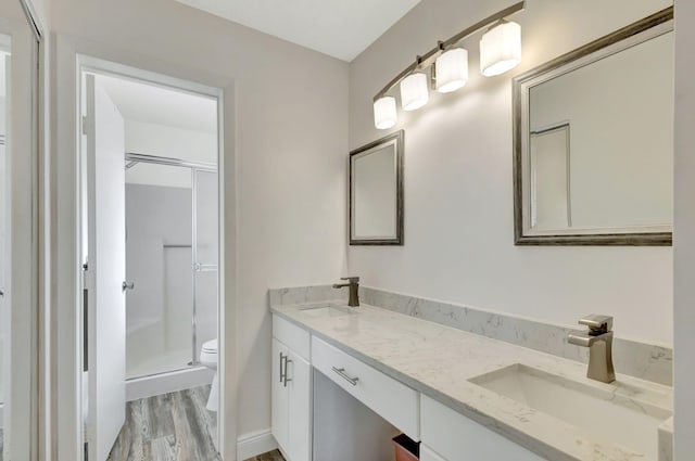 bathroom with vanity, toilet, wood-type flooring, and an enclosed shower