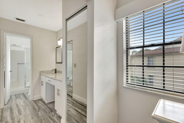 bathroom featuring vanity, an enclosed shower, hardwood / wood-style floors, and a healthy amount of sunlight