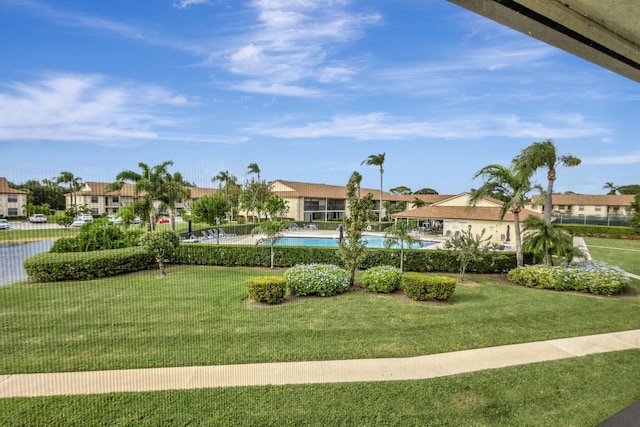 surrounding community with a yard and a swimming pool