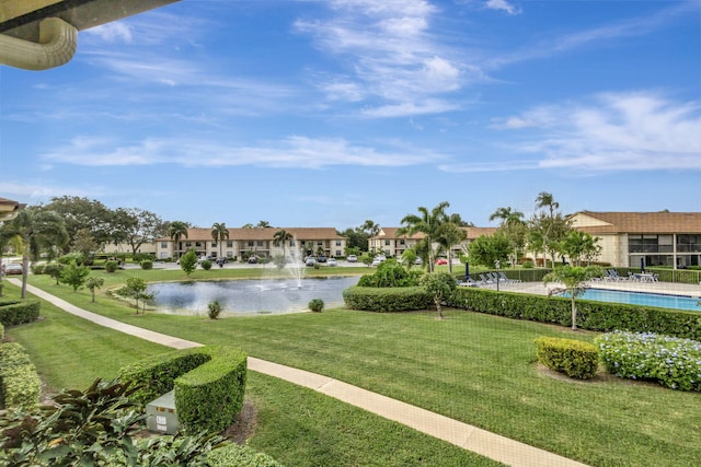 view of home's community featuring a swimming pool, a yard, and a water view