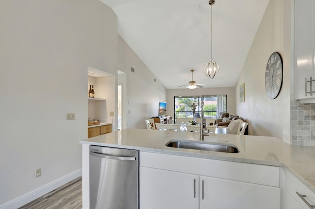 kitchen featuring light stone countertops, sink, light wood-type flooring, white cabinetry, and decorative light fixtures