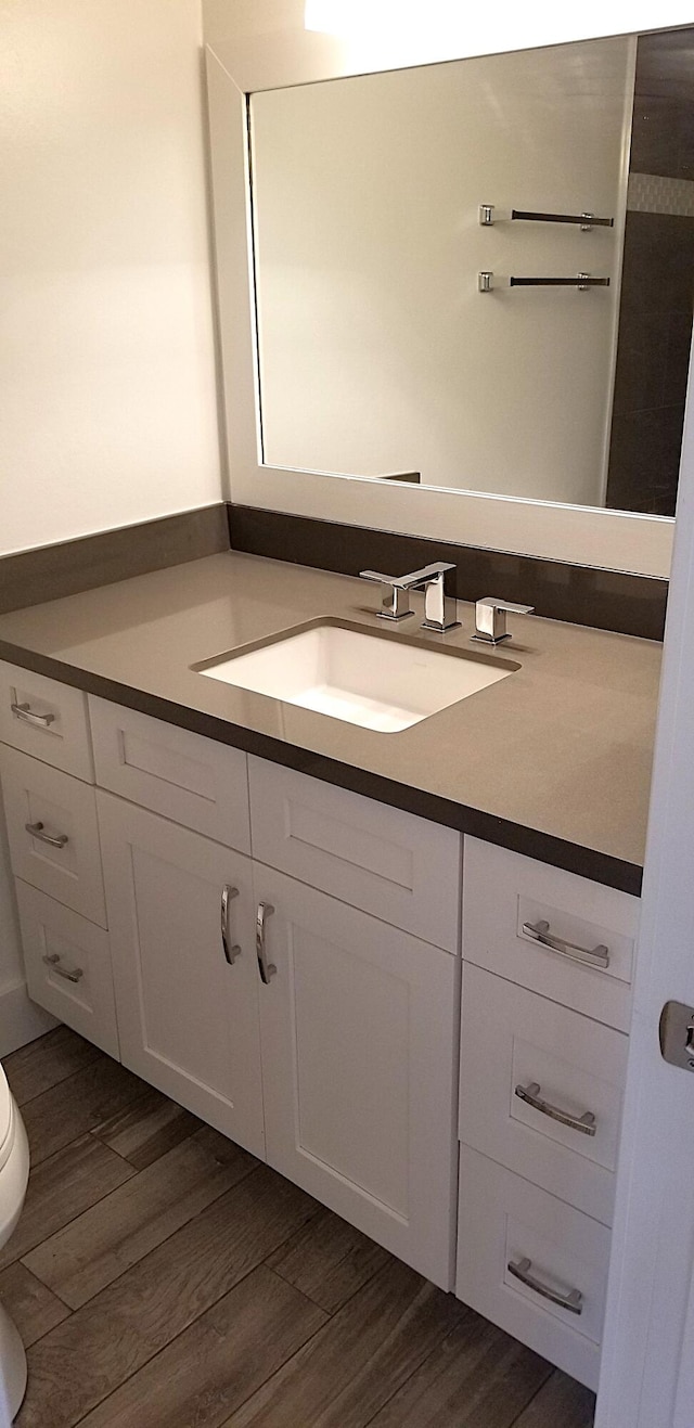 bathroom with vanity, hardwood / wood-style flooring, and toilet