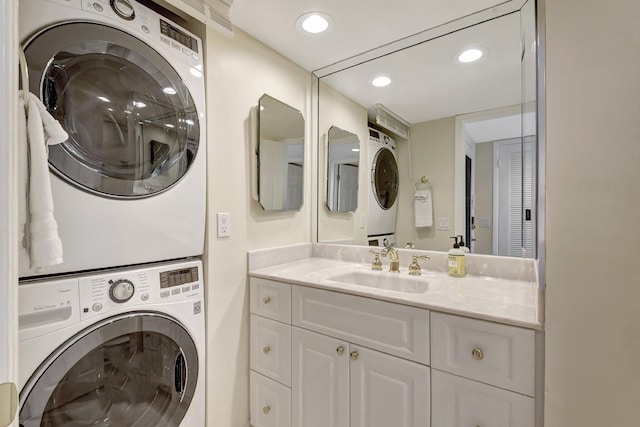 laundry area with stacked washer / drying machine and sink