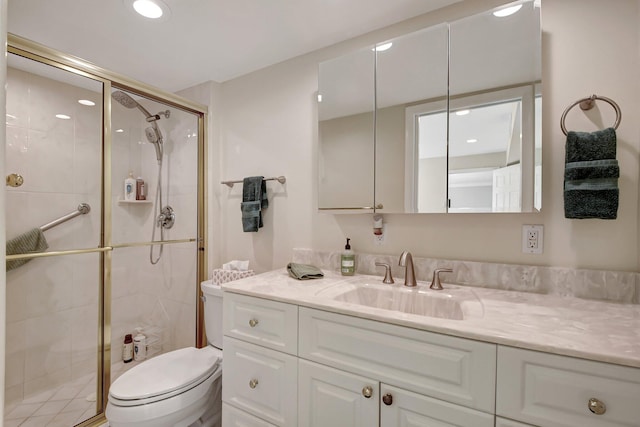 bathroom with vanity, toilet, and a shower with door