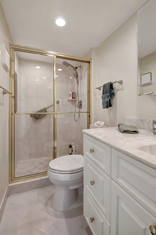 bathroom with tile patterned flooring, vanity, toilet, and a shower with door