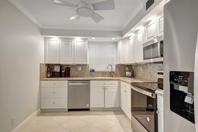 kitchen with decorative backsplash, white cabinetry, stainless steel appliances, and ornamental molding