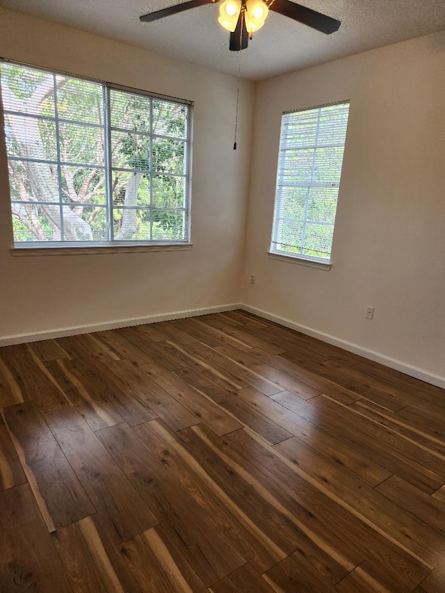 empty room featuring ceiling fan and dark hardwood / wood-style flooring