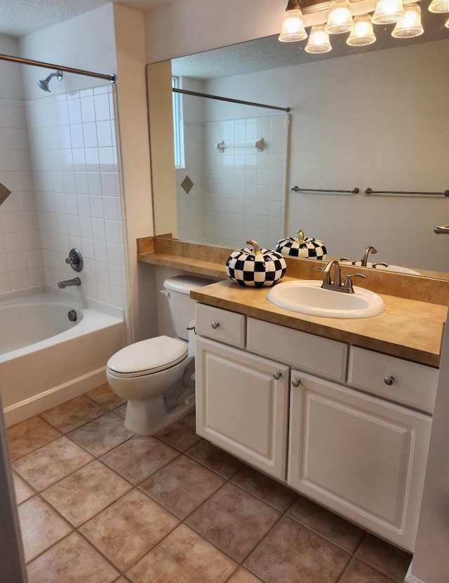 full bathroom with tile patterned flooring, tiled shower / bath, a textured ceiling, vanity, and toilet