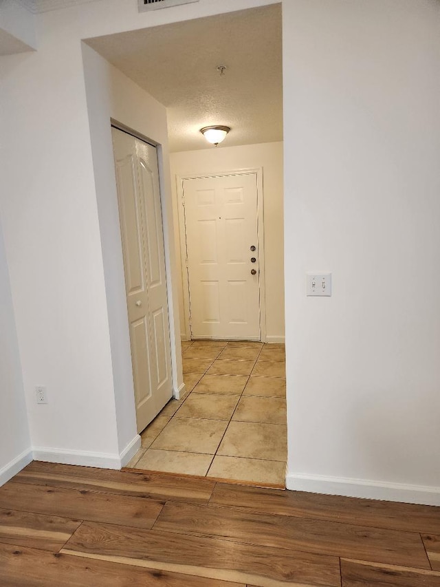 hallway featuring a textured ceiling and hardwood / wood-style flooring