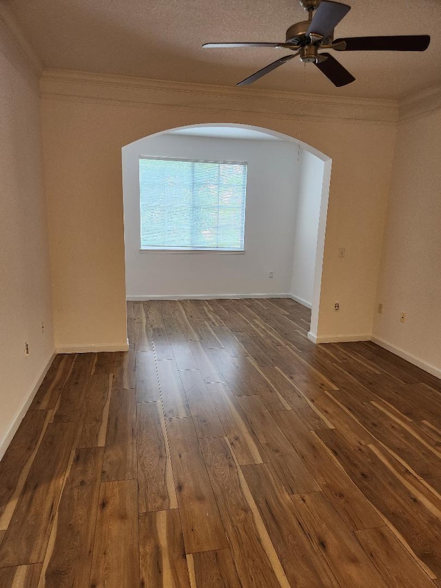 unfurnished room featuring dark wood-type flooring, a textured ceiling, ceiling fan, and crown molding