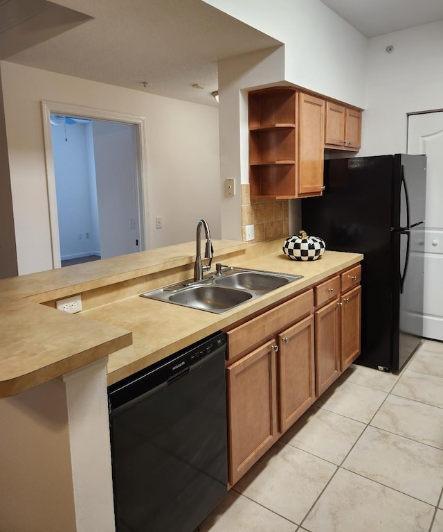 kitchen with black appliances, kitchen peninsula, sink, and light tile patterned floors