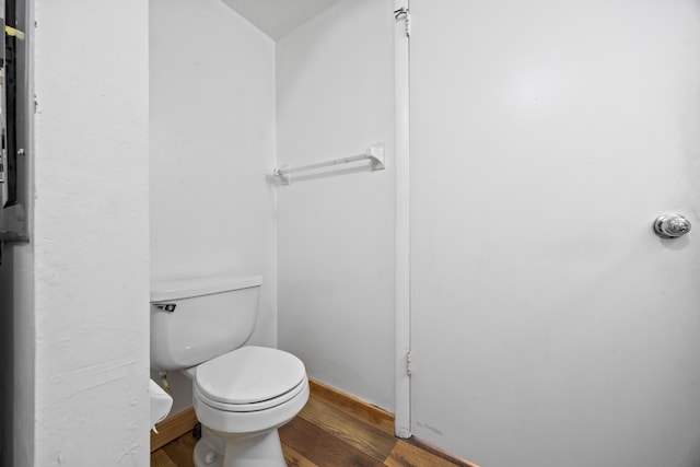 bathroom with toilet and wood finished floors