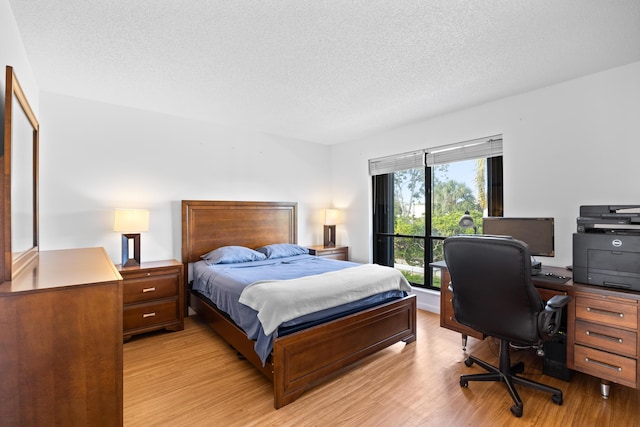 bedroom featuring light wood-type flooring and a textured ceiling