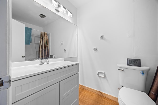 full bath with vanity, a shower with shower curtain, wood finished floors, and toilet